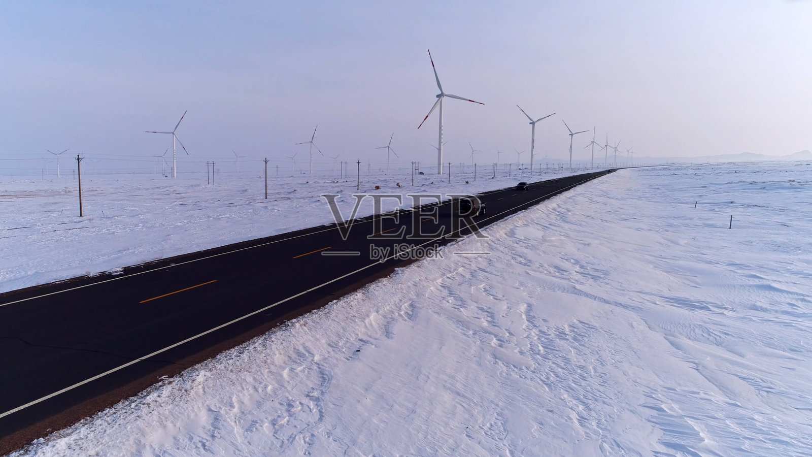 冬季，中国新疆，亚洲的风力发电场与雪景。照片摄影图片