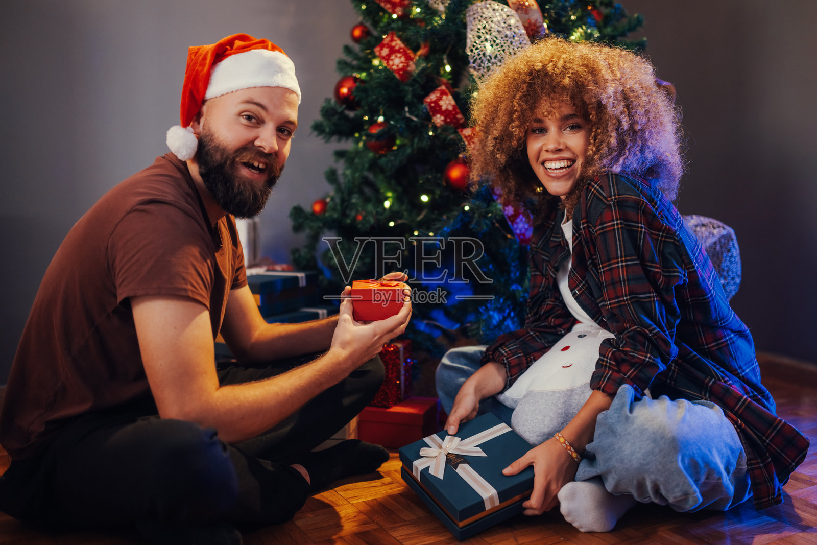 快乐的情侣在家中互赠圣诞礼物照片摄影图片