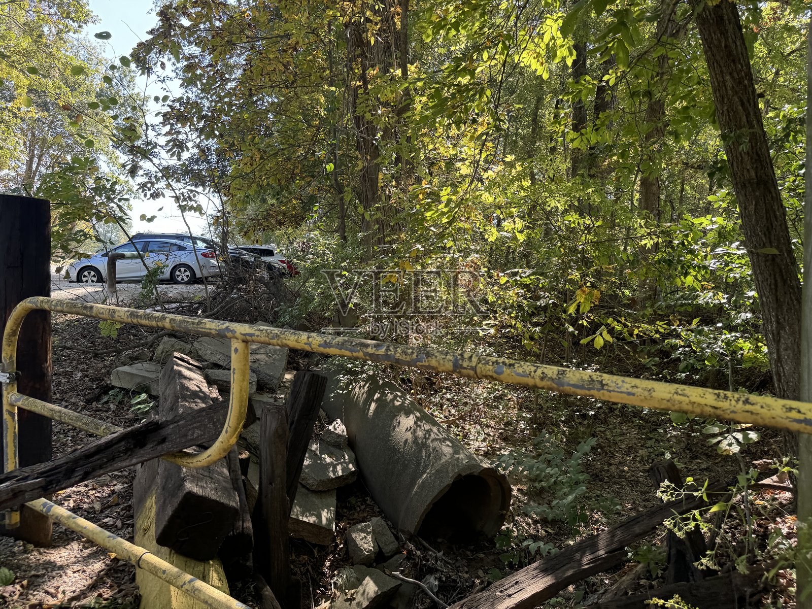 废弃的建筑垃圾和路边封闭区域附近的杂草丛生的植被照片摄影图片