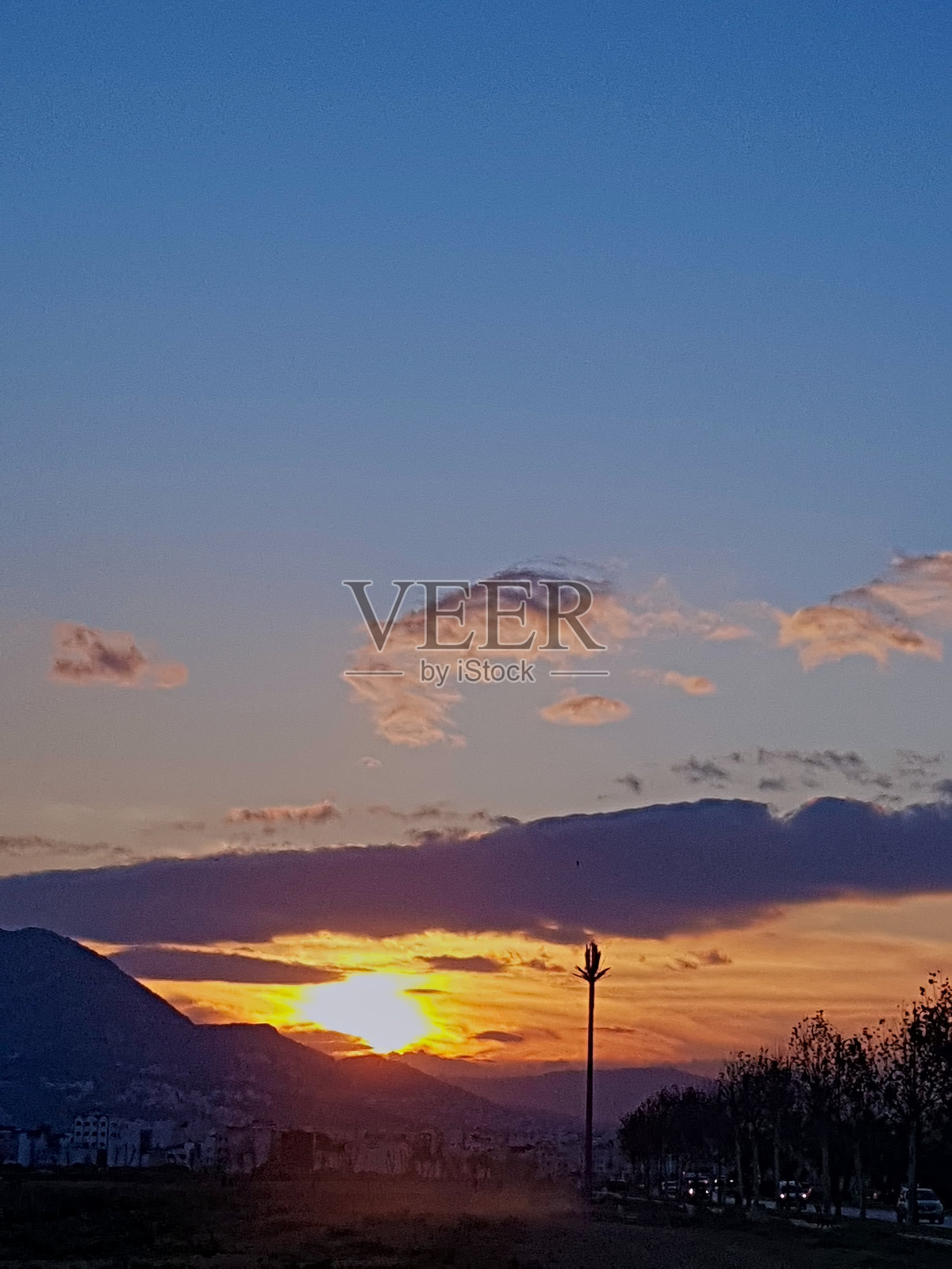 黄昏的地平线在日落时拥抱着云彩，阳光照耀在云层上，创造出绚丽的色彩。照片摄影图片