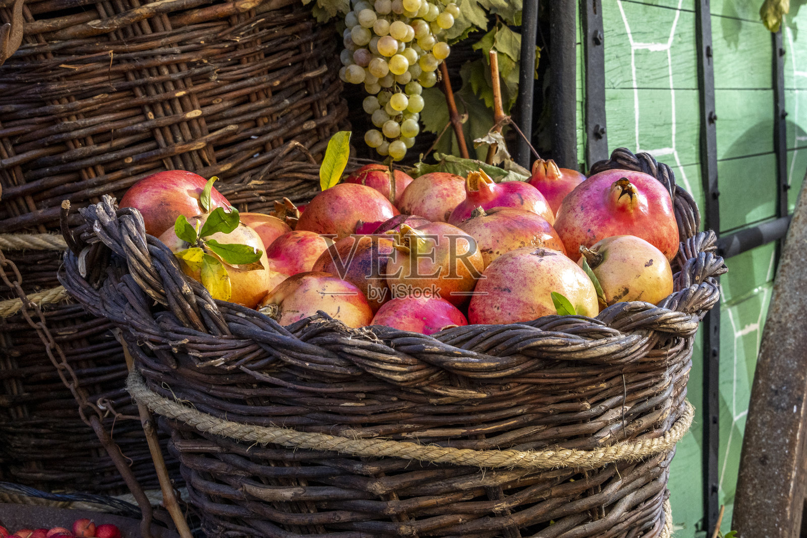 户外市场上藤编篮子里的成熟石榴照片摄影图片