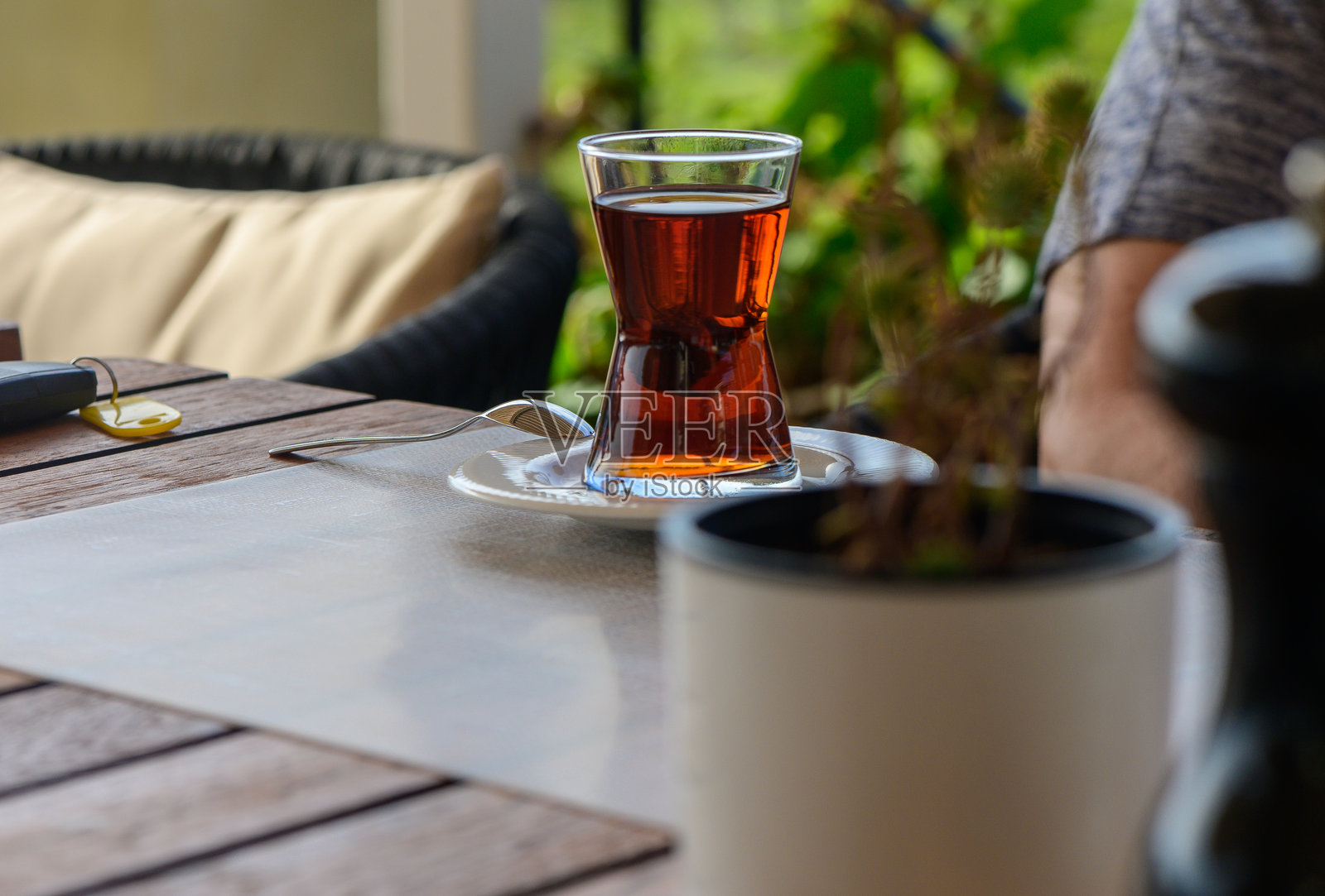 宁静的下午茶在花园咖啡馆，俯瞰郁郁葱葱的绿意，桌上摆放着一杯香气四溢的饮品。照片摄影图片