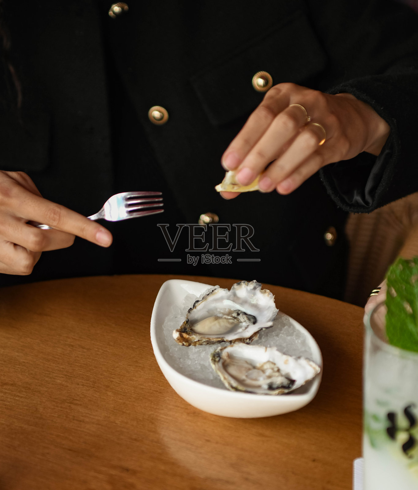 一个人正在给一些高品质的生蚝倒柠檬汁照片摄影图片