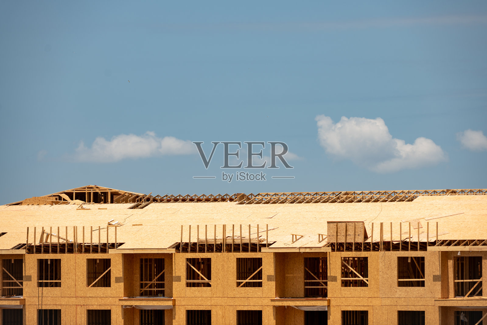 房屋的框架和屋顶。房屋的木框架与蓝天相映成趣。小屋的框架。房屋建设的开始。建筑工地。木结构房屋。照片摄影图片