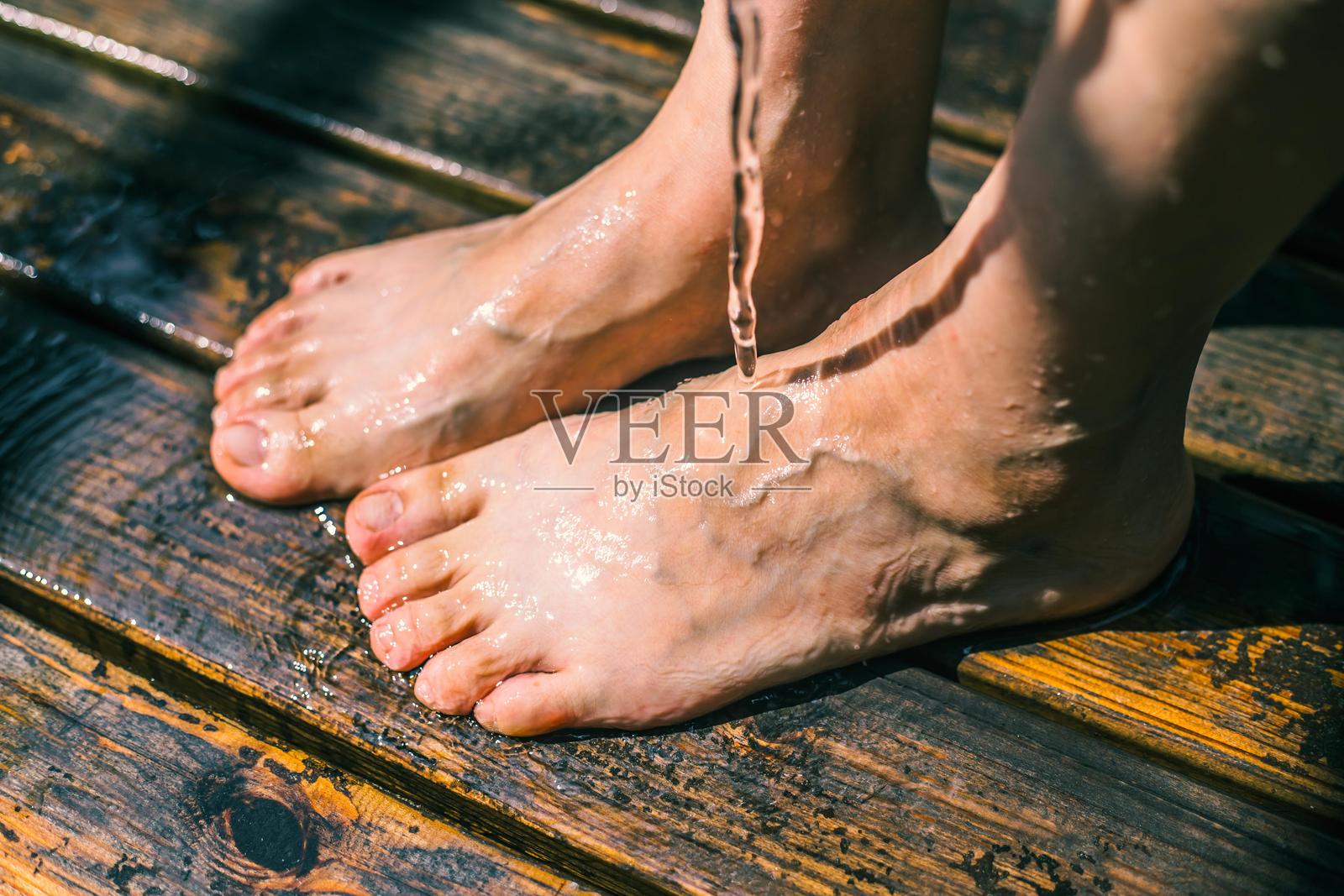 女人的脚在木栈道上沾湿照片摄影图片