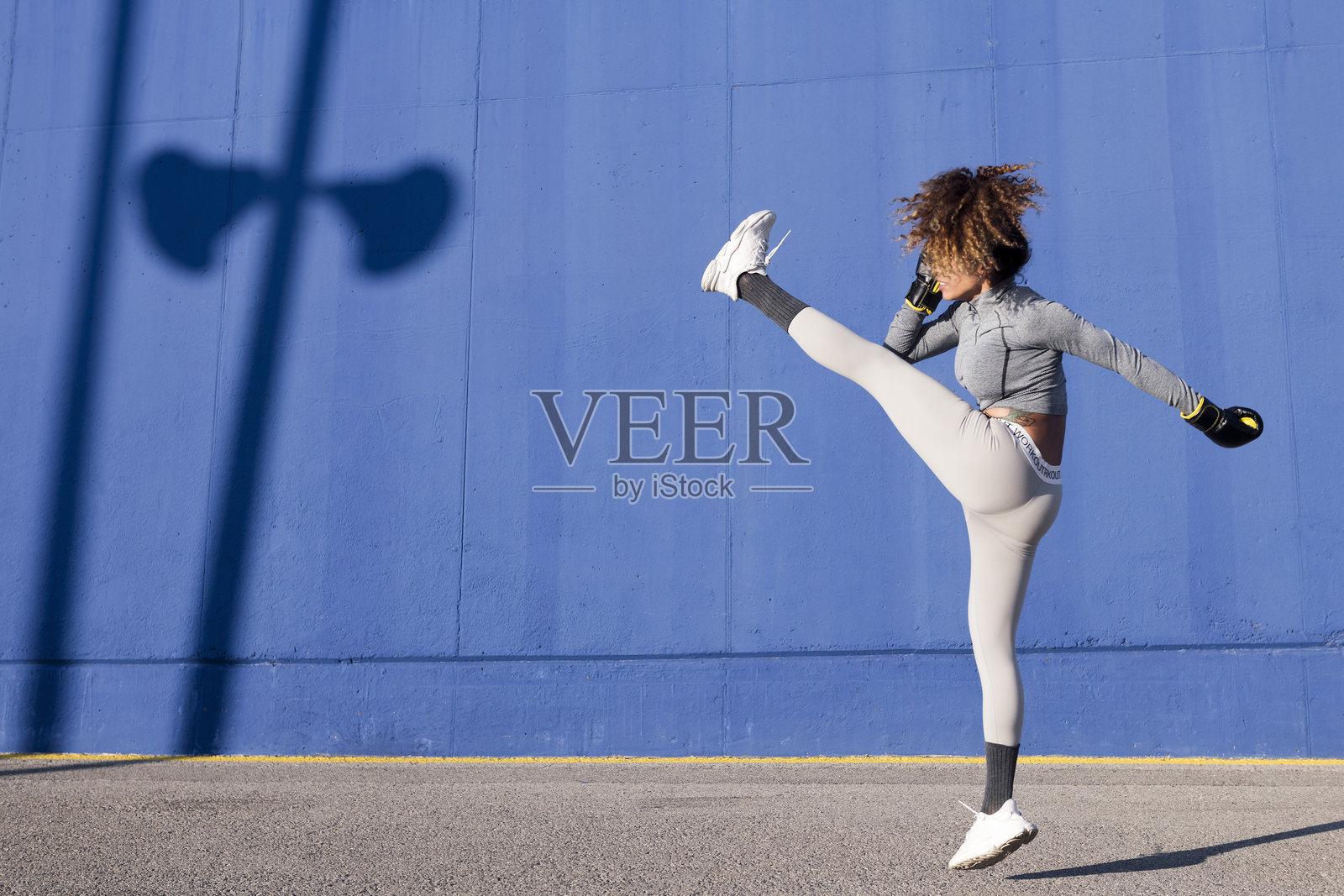 拉丁女性战士抬腿踢击照片摄影图片