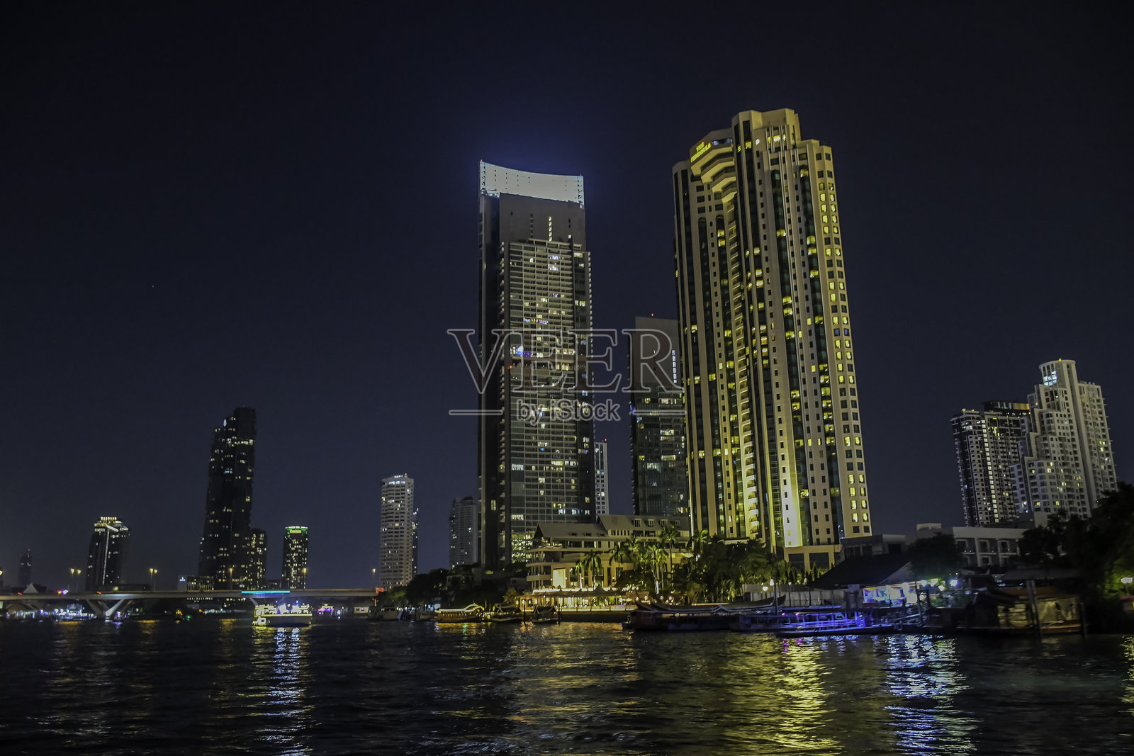 夜晚的曼谷城市天际线和照亮的摩天大楼，靠近湄南河照片摄影图片