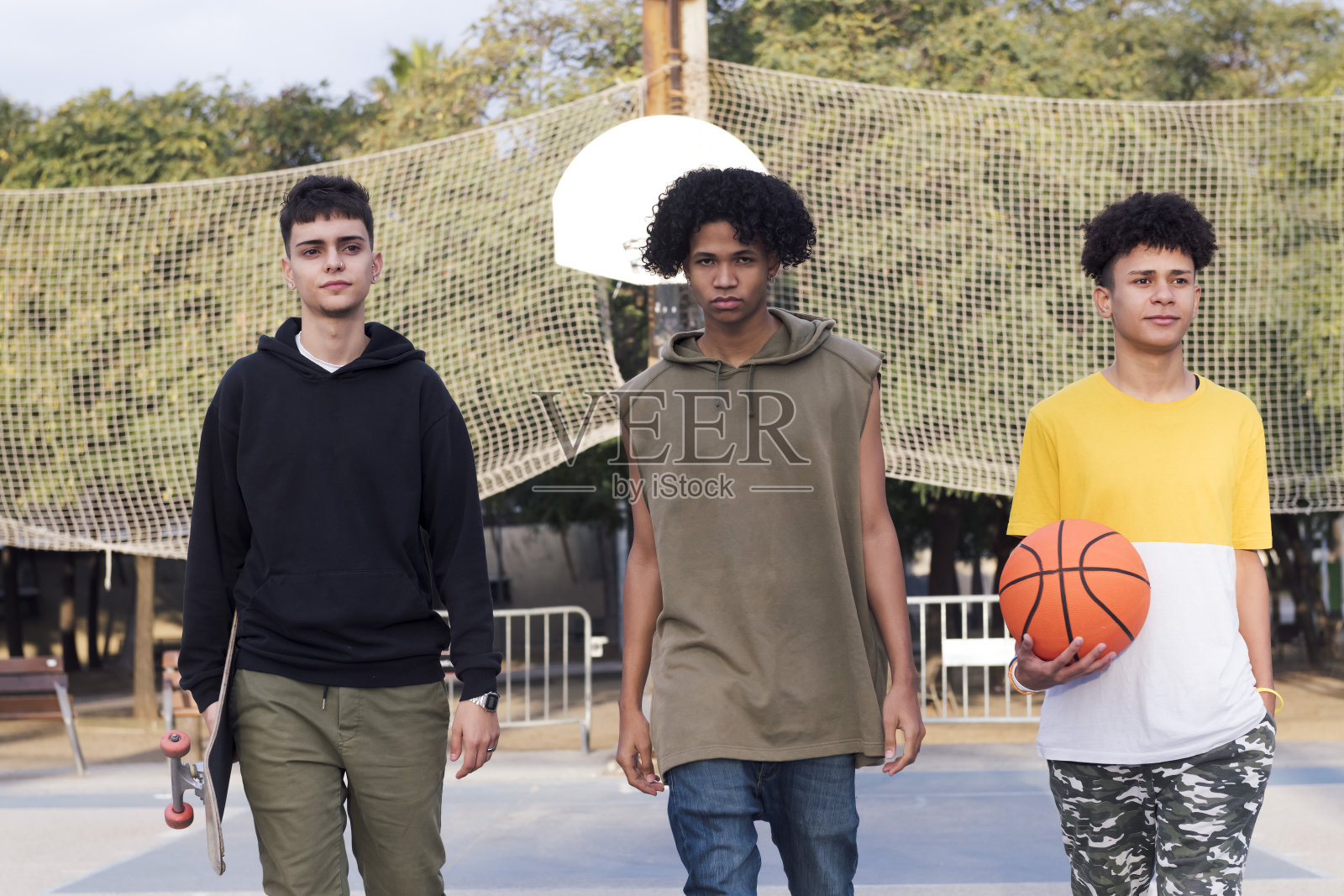 三个自信的青少年在运动场上走动照片摄影图片