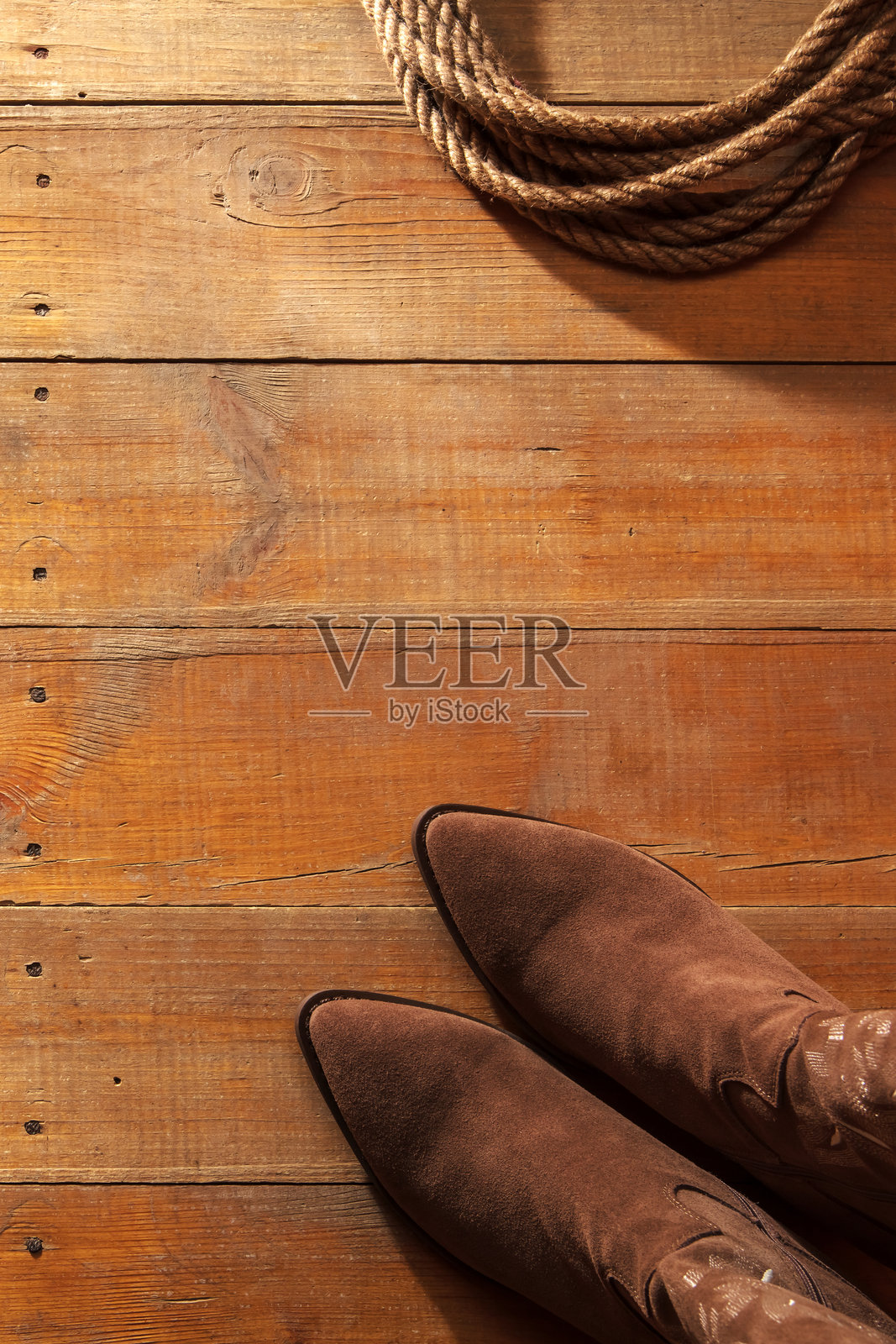 牛仔靴与绳索置于谷仓木背景上照片摄影图片