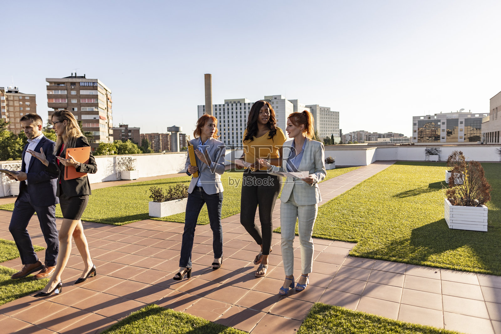 商务人士在屋顶露台上走动并交谈照片摄影图片