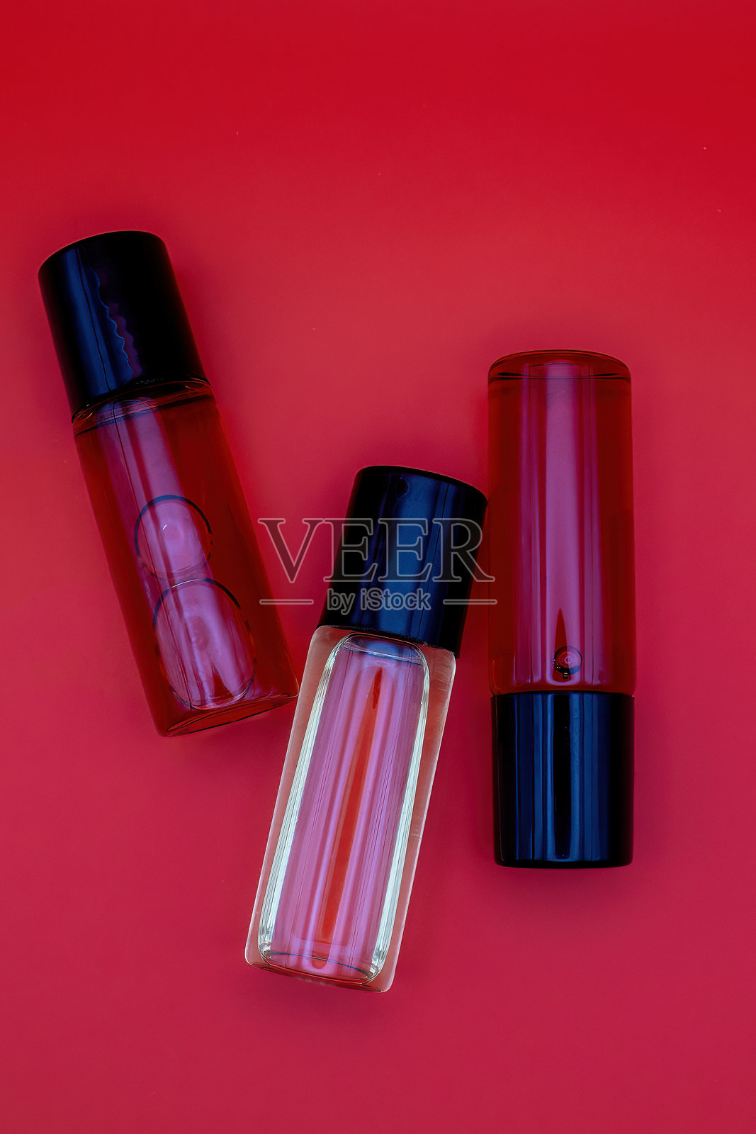 香水瓶。红色背景。女性香水，香油，留有您的文字位置。照片摄影图片