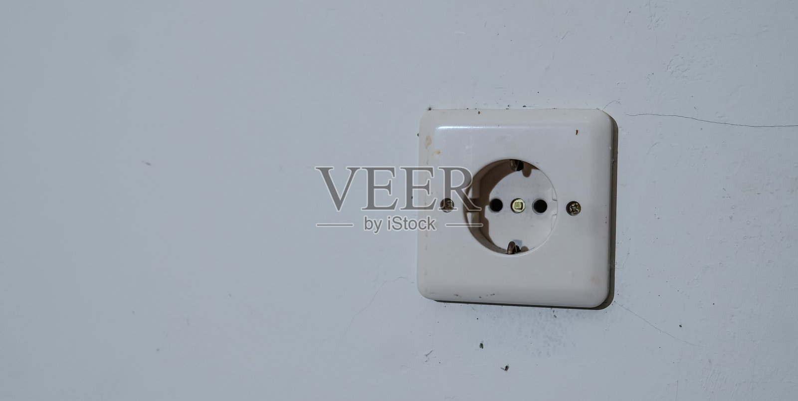 墙壁上的电插头中部特写。照片摄影图片