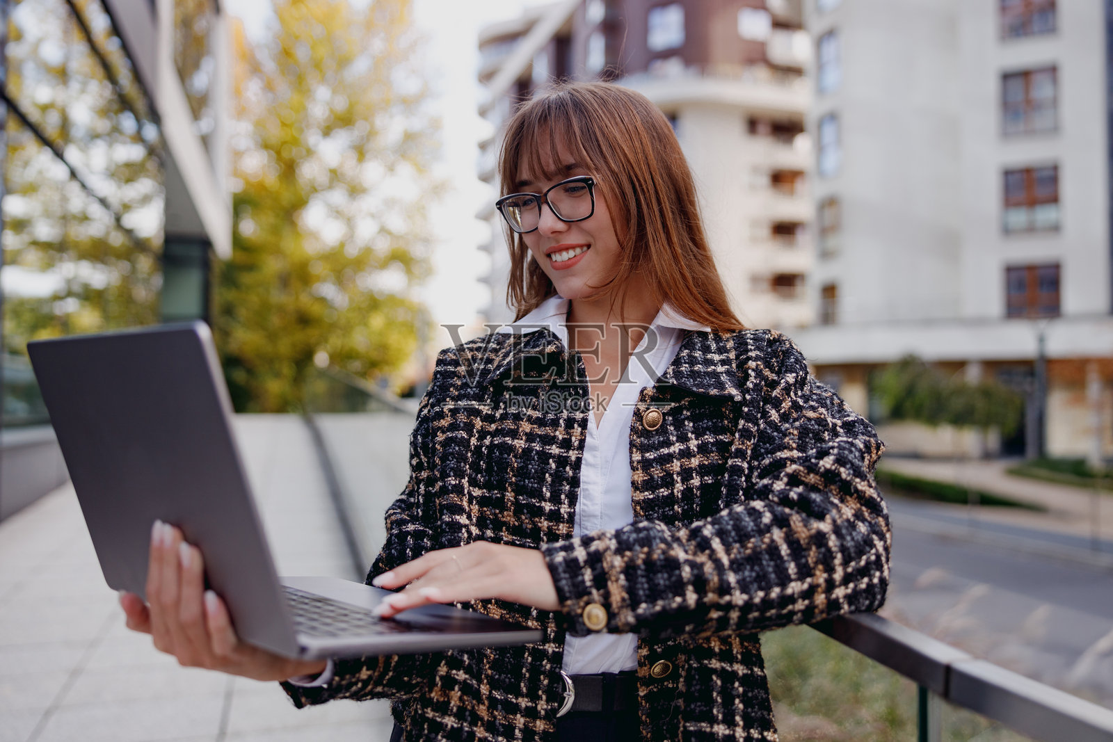 一位年轻女性在户外远程工作，享受大自然和新鲜空气，手边有她的笔记本电脑。照片摄影图片