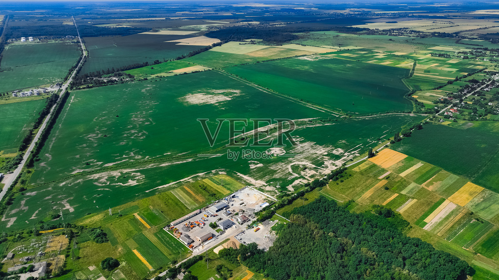 夏季郊区乡村的航拍无人机视角，工业厂房和靠近田野的谷仓，周围是绿色草地。照片摄影图片