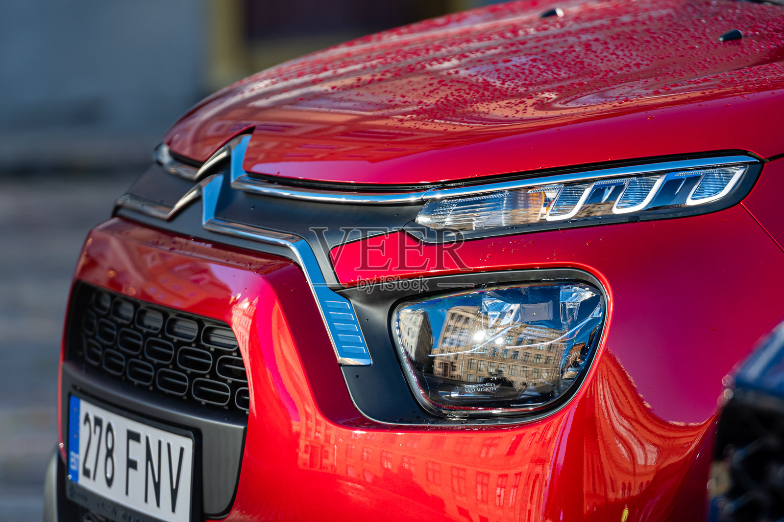 城市中雨天的红色车辆特写,配有现代化的车灯照片摄影图片