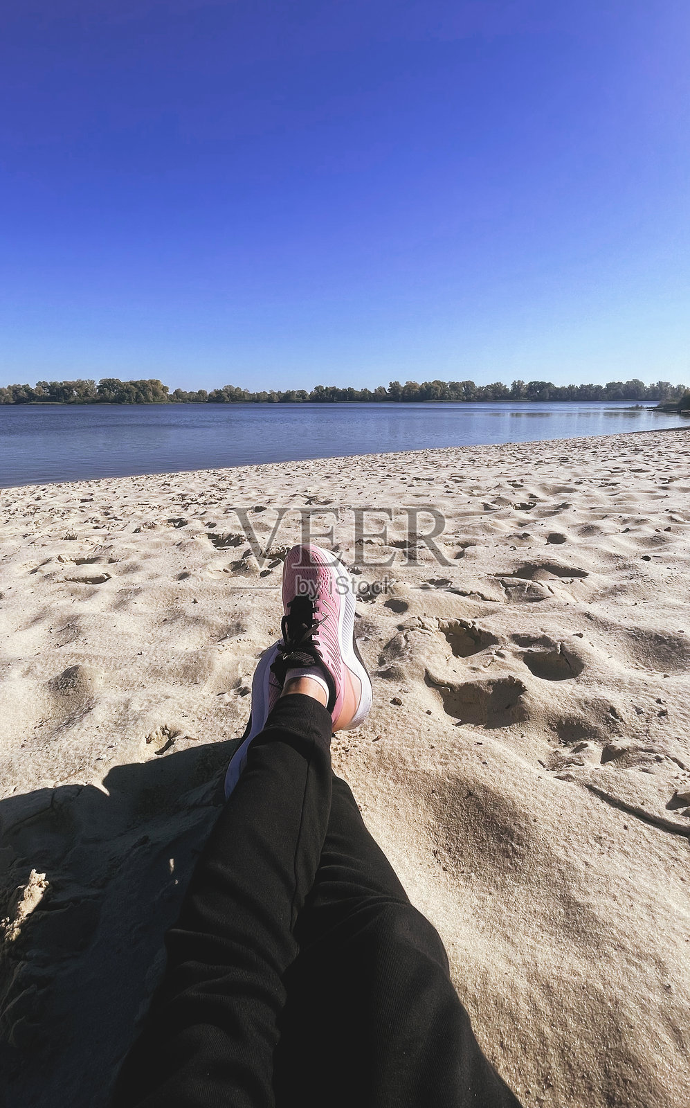 穿着运动鞋的游客在海滩上放松。照片摄影图片