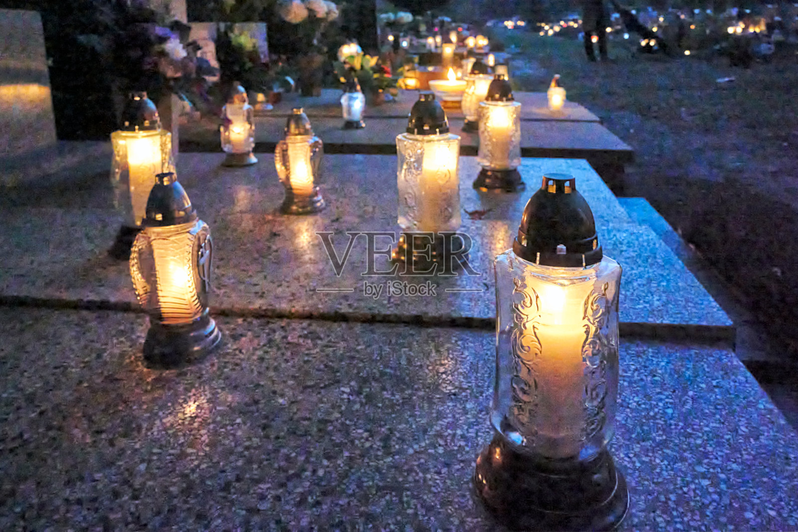 雕像，万圣节公墓坟墓上的蜡烛和鲜花照片摄影图片