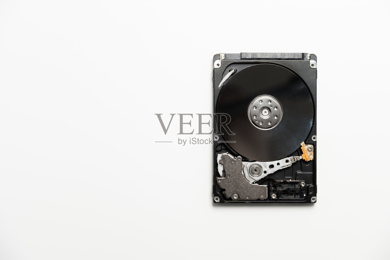 拆解的硬盘在白色背景上。存储设备的电子内部，读写头。照片摄影图片