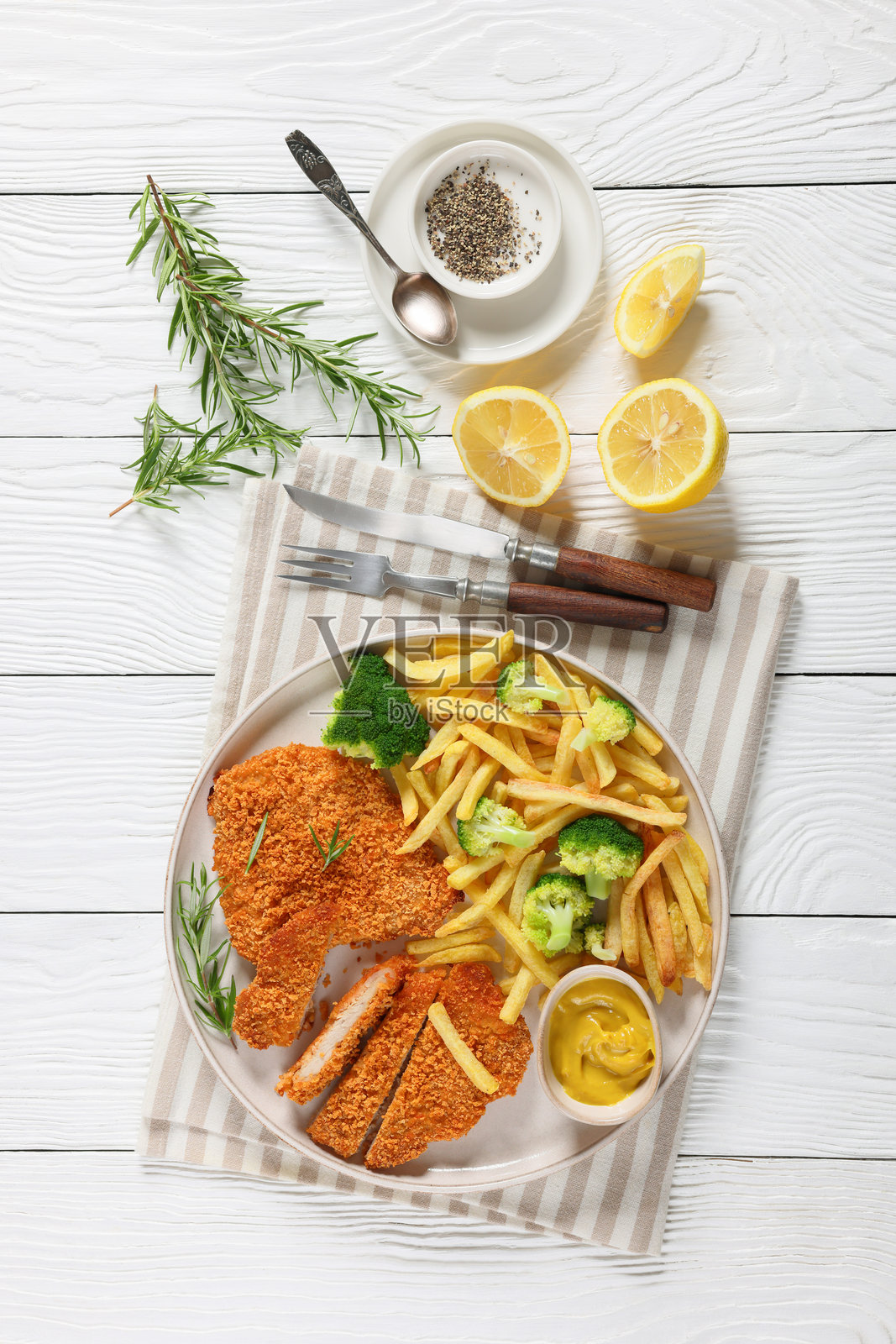 炸猪排配薯条和西兰花在盘子里照片摄影图片