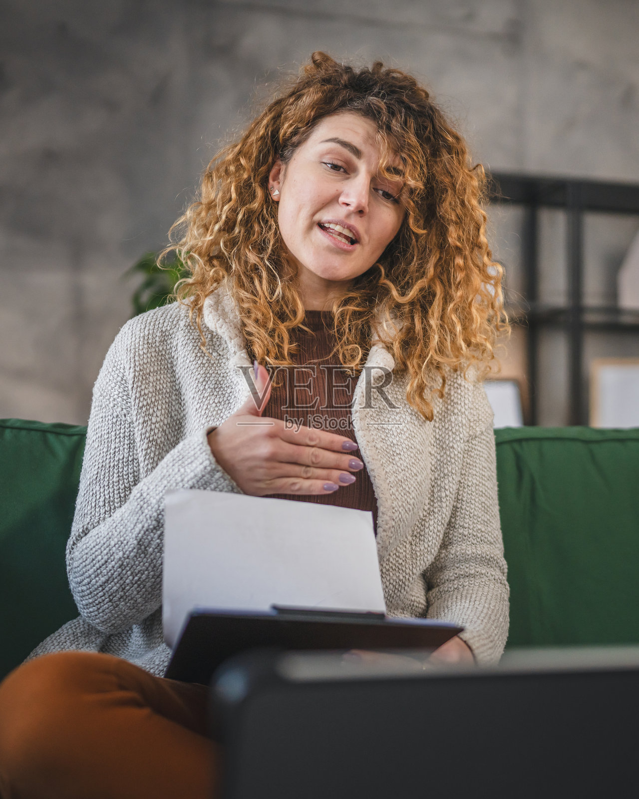 一位女性在家工作，通过数字平板进行视频通话。照片摄影图片