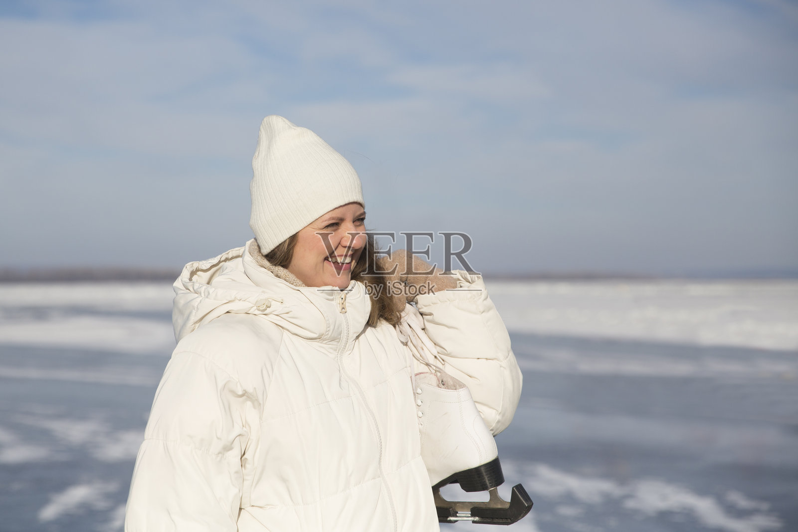 冬季自然中，穿着冰鞋的快乐女性在冰冻湖面上。享受生活中的小确幸。冬季氛围。圣诞假期。照片摄影图片