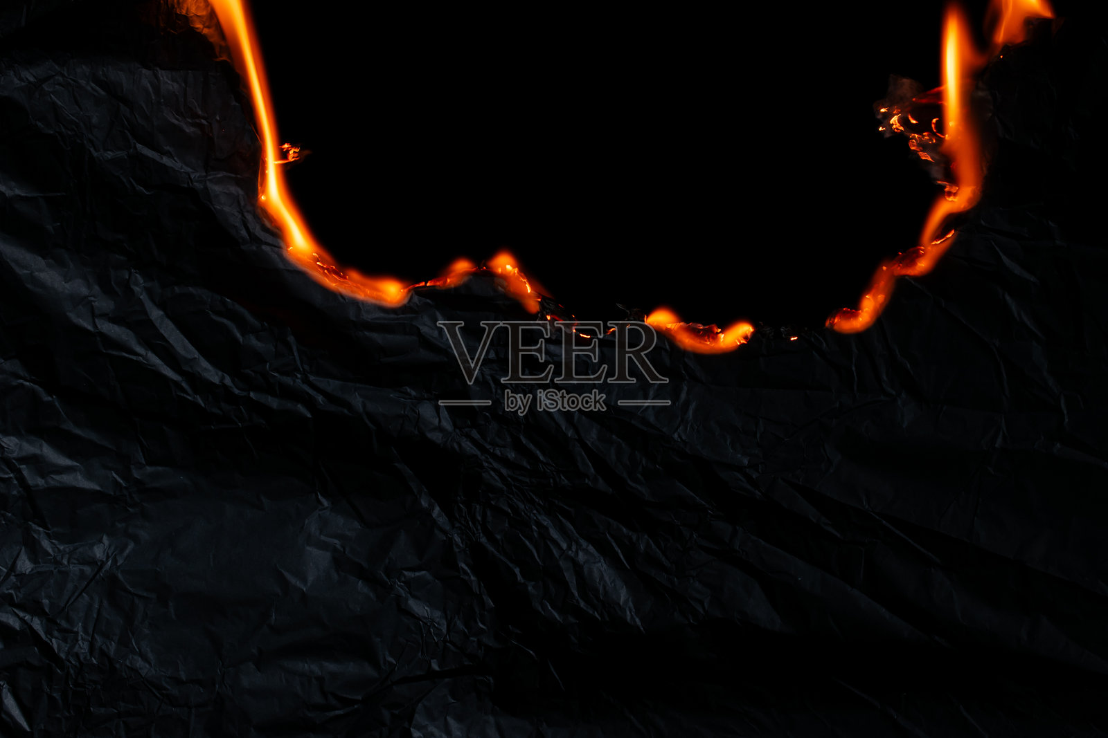 燃烧的纸张，黑色背景上的发光纸边缘照片摄影图片