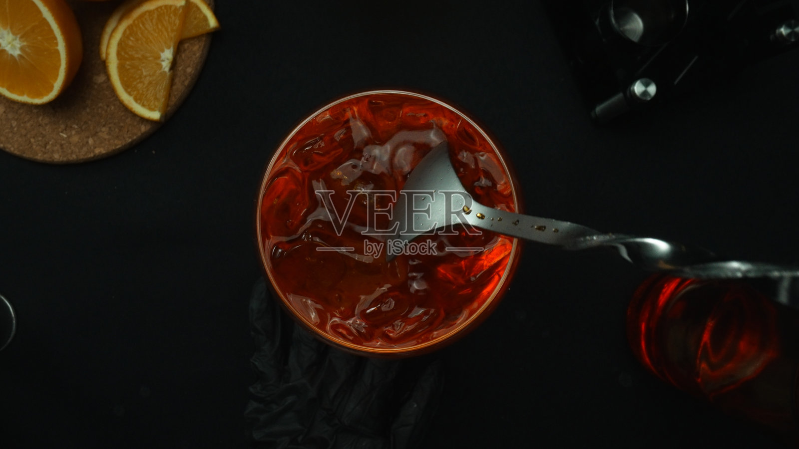从俯视角拍摄的尼格罗尼鸡尾酒混合过程的特写镜头。可食用。照片摄影图片