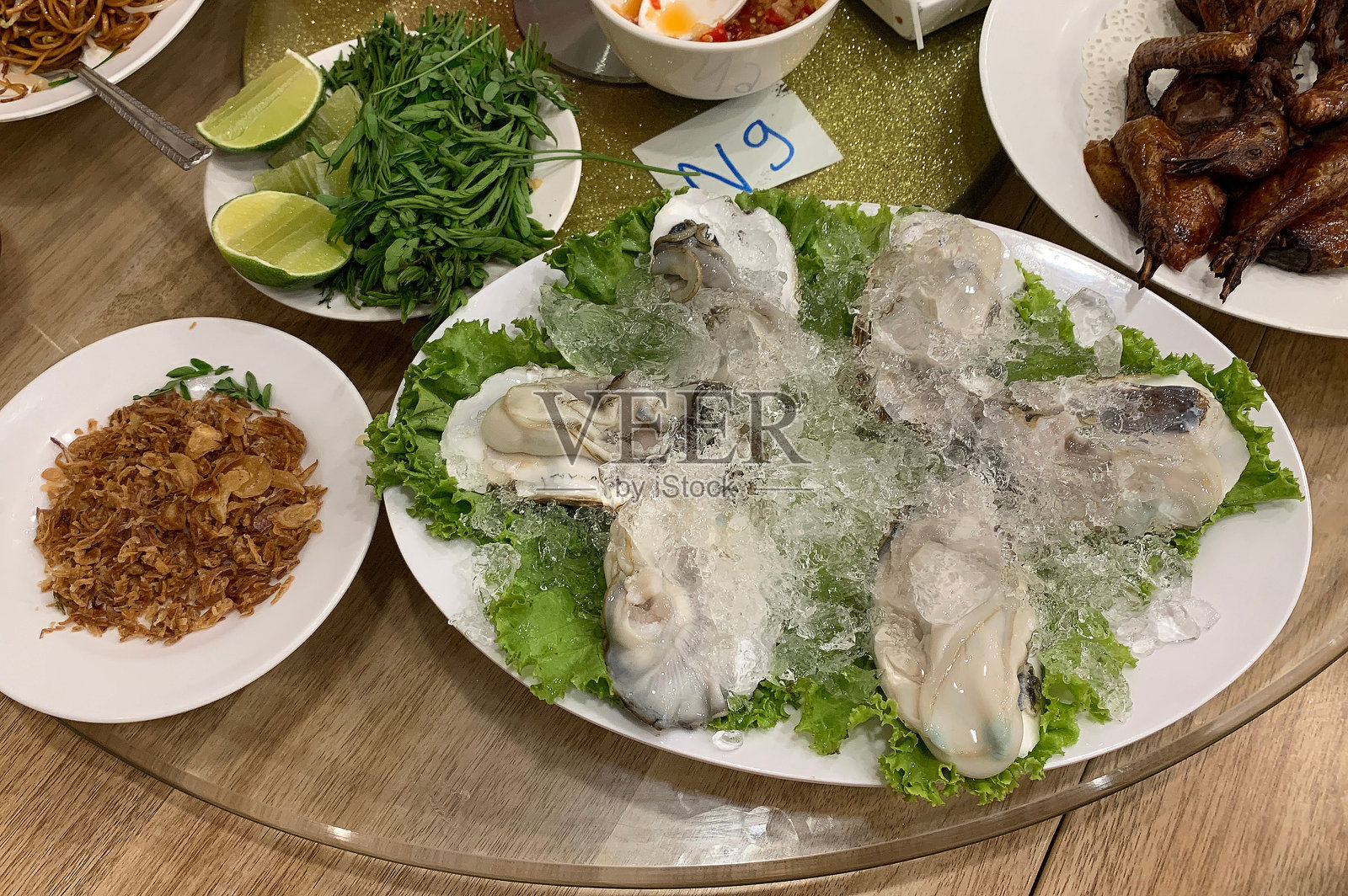 新鲜生蚝配冰块和酥脆的炸洋葱照片摄影图片