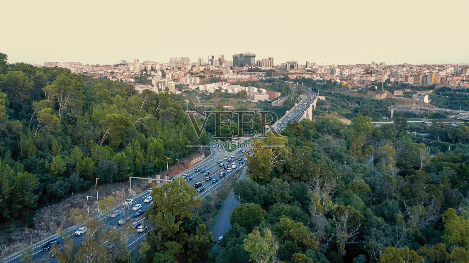 里斯本的大森林公园蒙萨托，公路穿过其郁郁葱葱的绿意。公园茂密的树木和植被与下面繁忙的交通形成了自然的对比。照片摄影图片