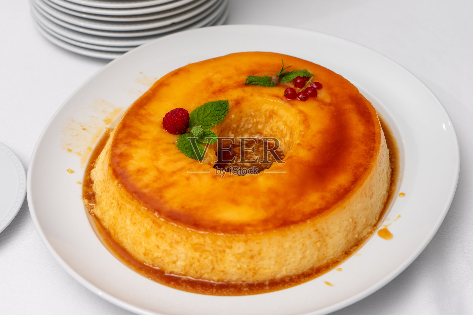 奶油蛋布丁，装饰以薄荷叶和覆盆子。照片摄影图片