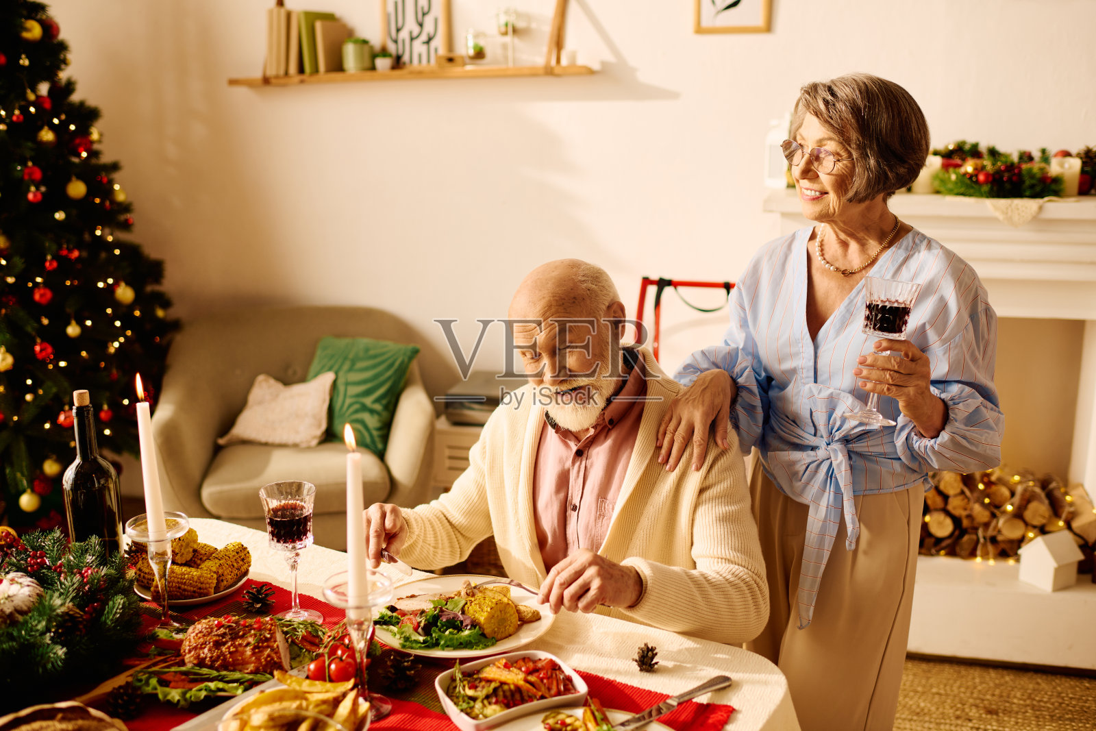 一对恩爱老年夫妇在温馨的家居氛围中珍惜圣诞晚餐时光照片摄影图片