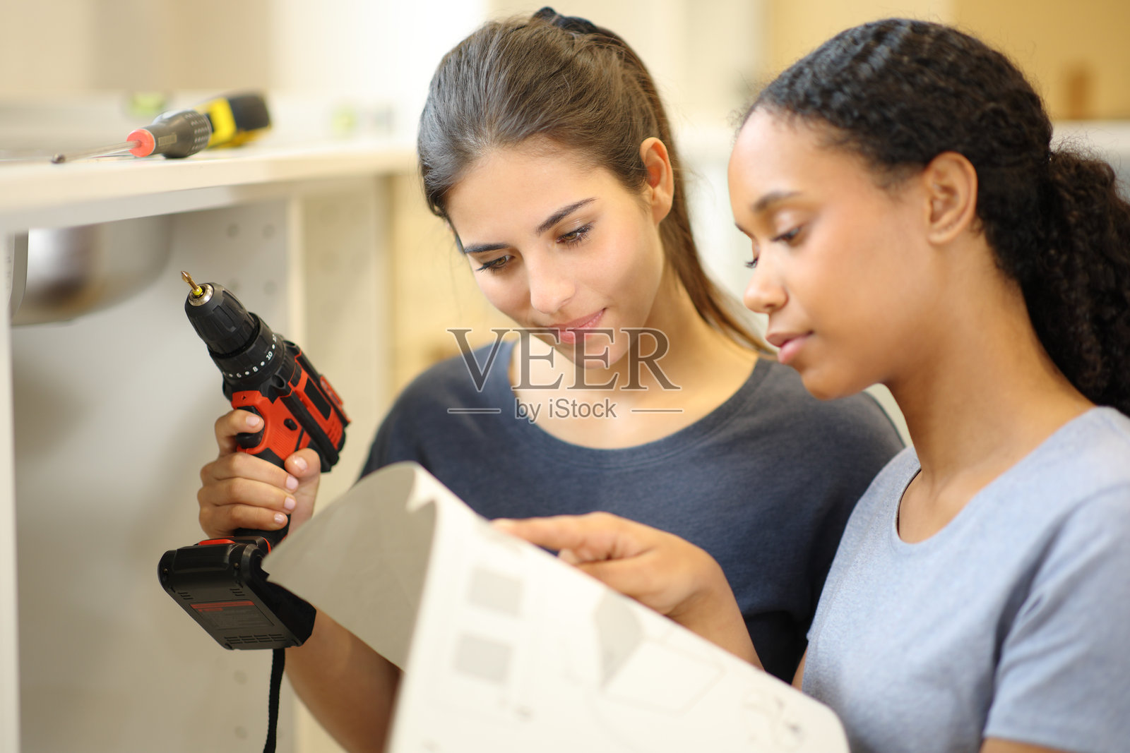 跨种族室友查看手册以安装家具照片摄影图片