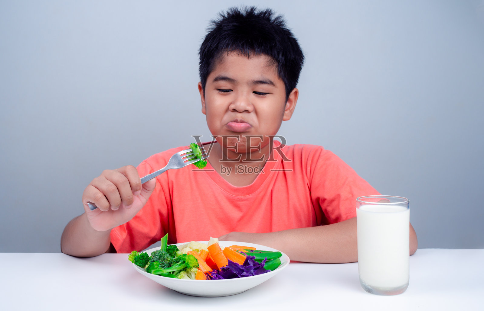 孩子们不喜欢吃蔬菜，小男孩拒绝吃健康的蔬菜，儿童营养健康饮食习惯的概念，孩子们不喜欢吃蔬菜。照片摄影图片