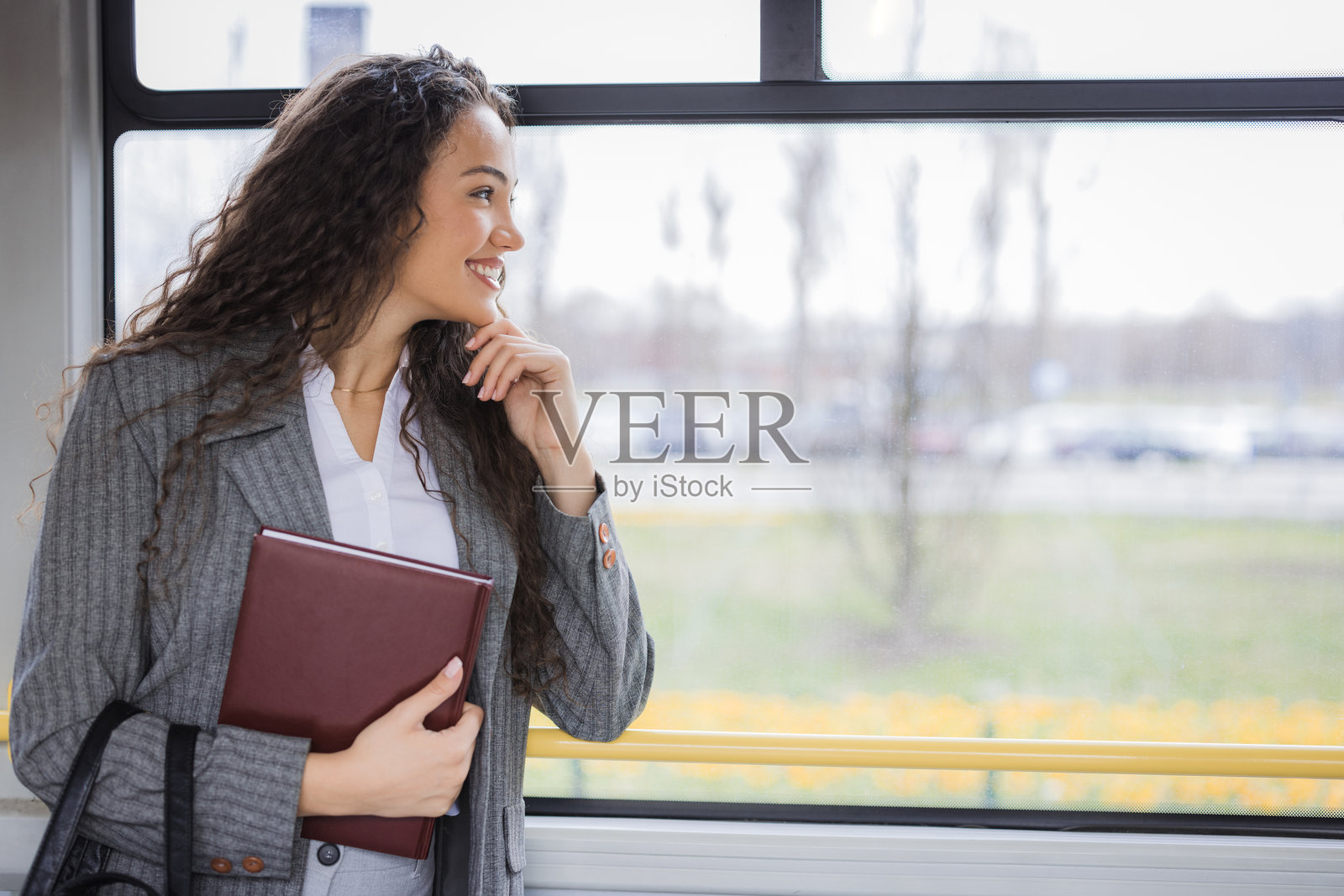 快乐的女学生透过公交车窗观察周围环境照片摄影图片