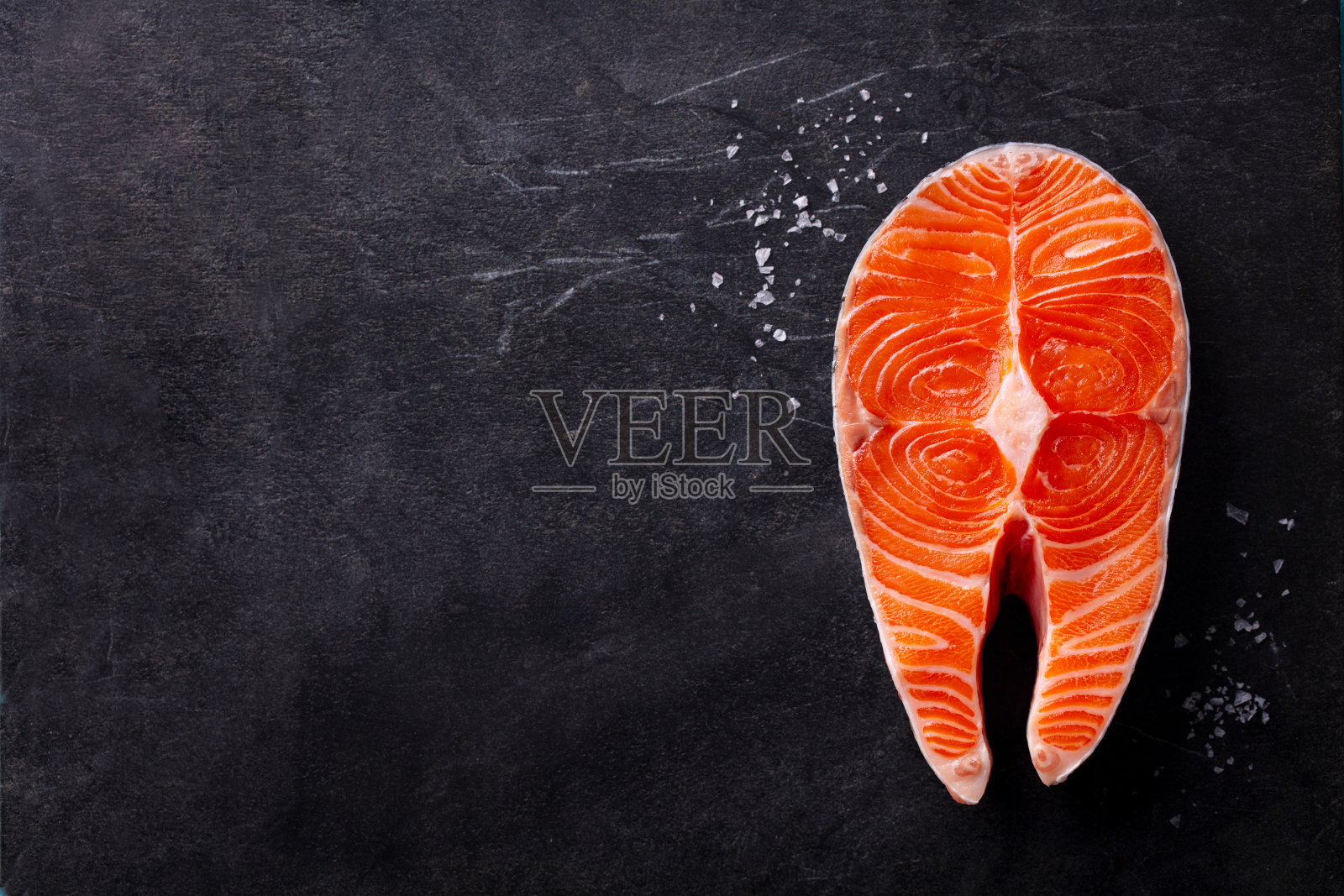 新鲜生三文鱼鱼片，牛排。深色背景。俯视图。留白空间。照片摄影图片