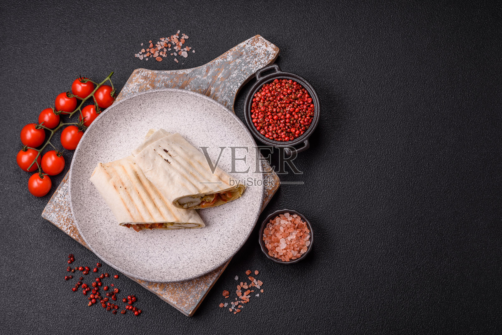 用皮塔饼卷肉、番茄、奶酪、酱汁、盐和香料照片摄影图片