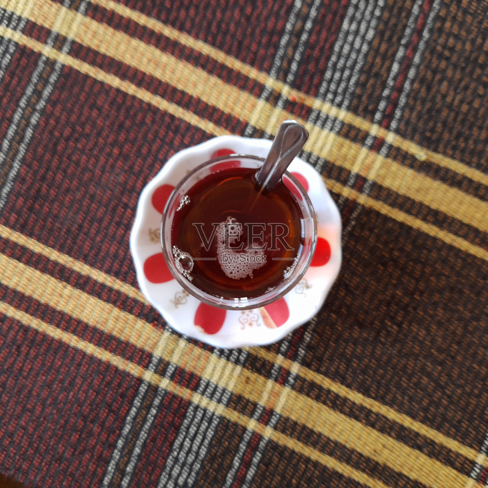 桌子上的茶杯里装着红茶。照片摄影图片