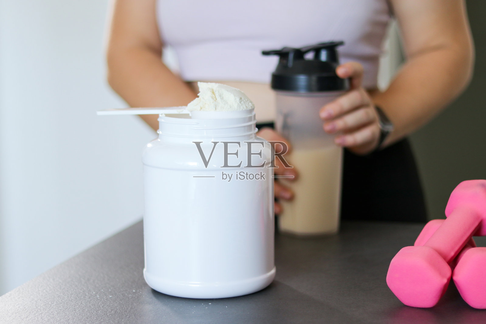 特写镜头：女性在厨房准备蛋白质奶昔。减肥的饮食替代餐。照片摄影图片