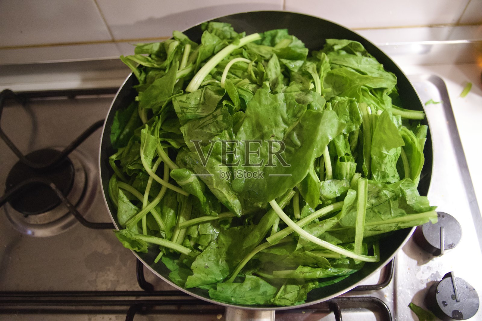 家厨房炉子上的一锅新鲜菠菜照片摄影图片