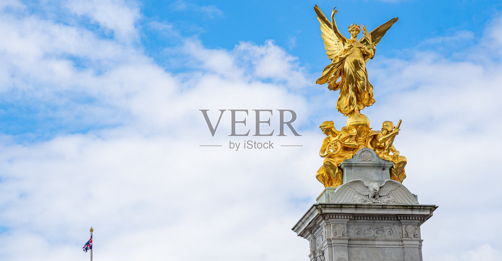 一群游客在白金汉宫和维多利亚纪念碑旁,纪念碑上有正义天使。照片摄影图片