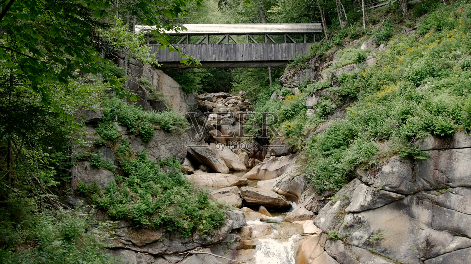 新罕布什尔州的岩石溪流上的有盖桥照片摄影图片