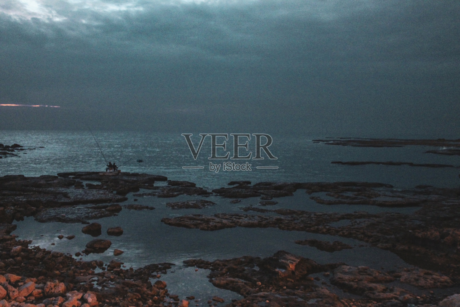 在比布鲁斯的岩石海岸上黄昏钓鱼照片摄影图片