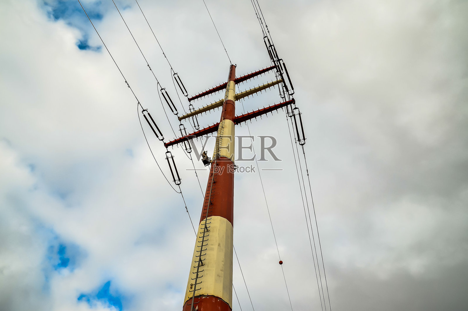 一根红白相间的高杆被电线环绕。照片摄影图片