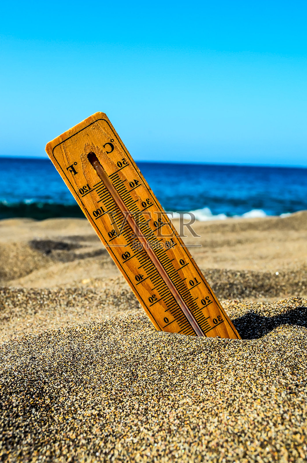 一个温度计放在沙滩上的沙子里照片摄影图片