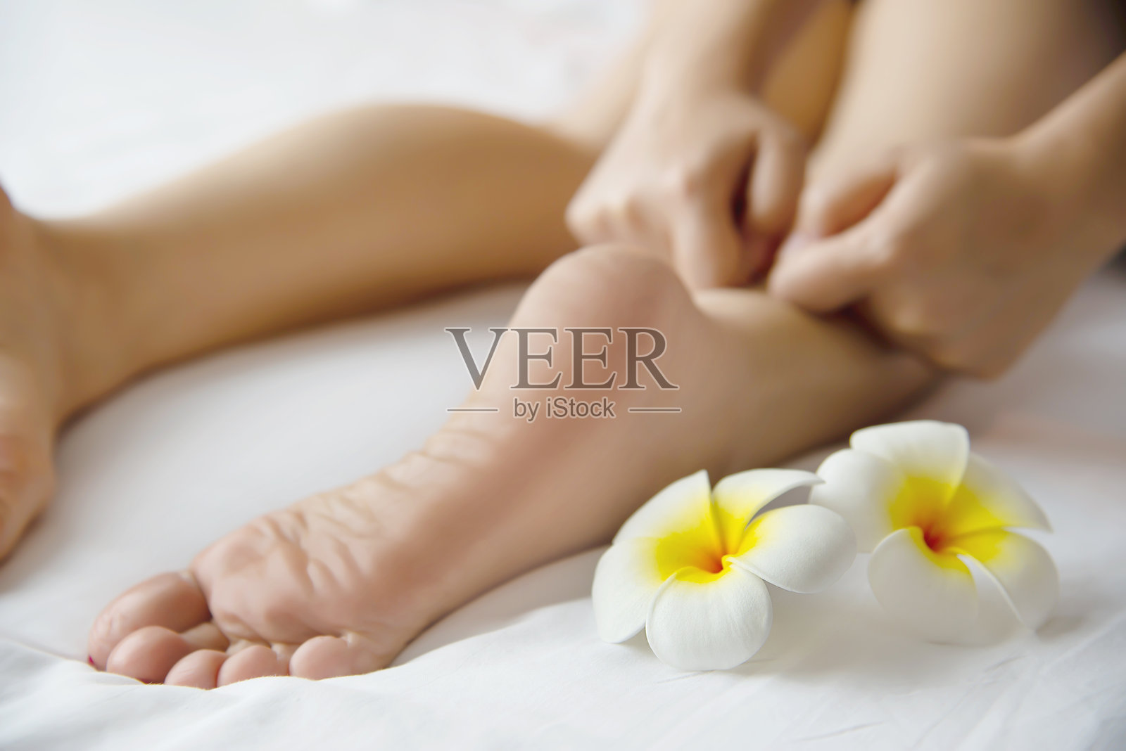 修剪的手在床上为躺着的女性按摩照片摄影图片