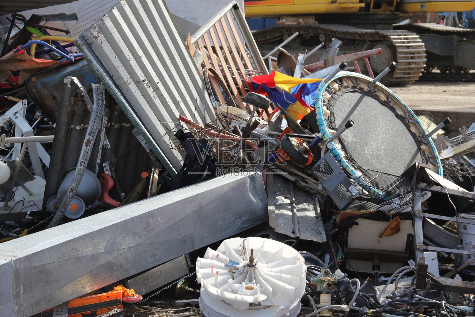 回收中心的废旧金属垃圾，包括家用电器、屋顶铁和迷你蹦床。照片摄影图片
