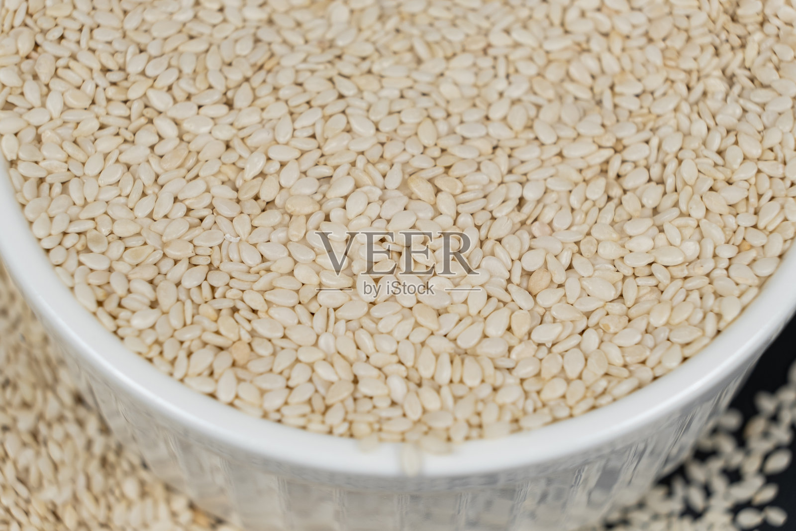 白色烤芝麻放在盘子里。照片摄影图片