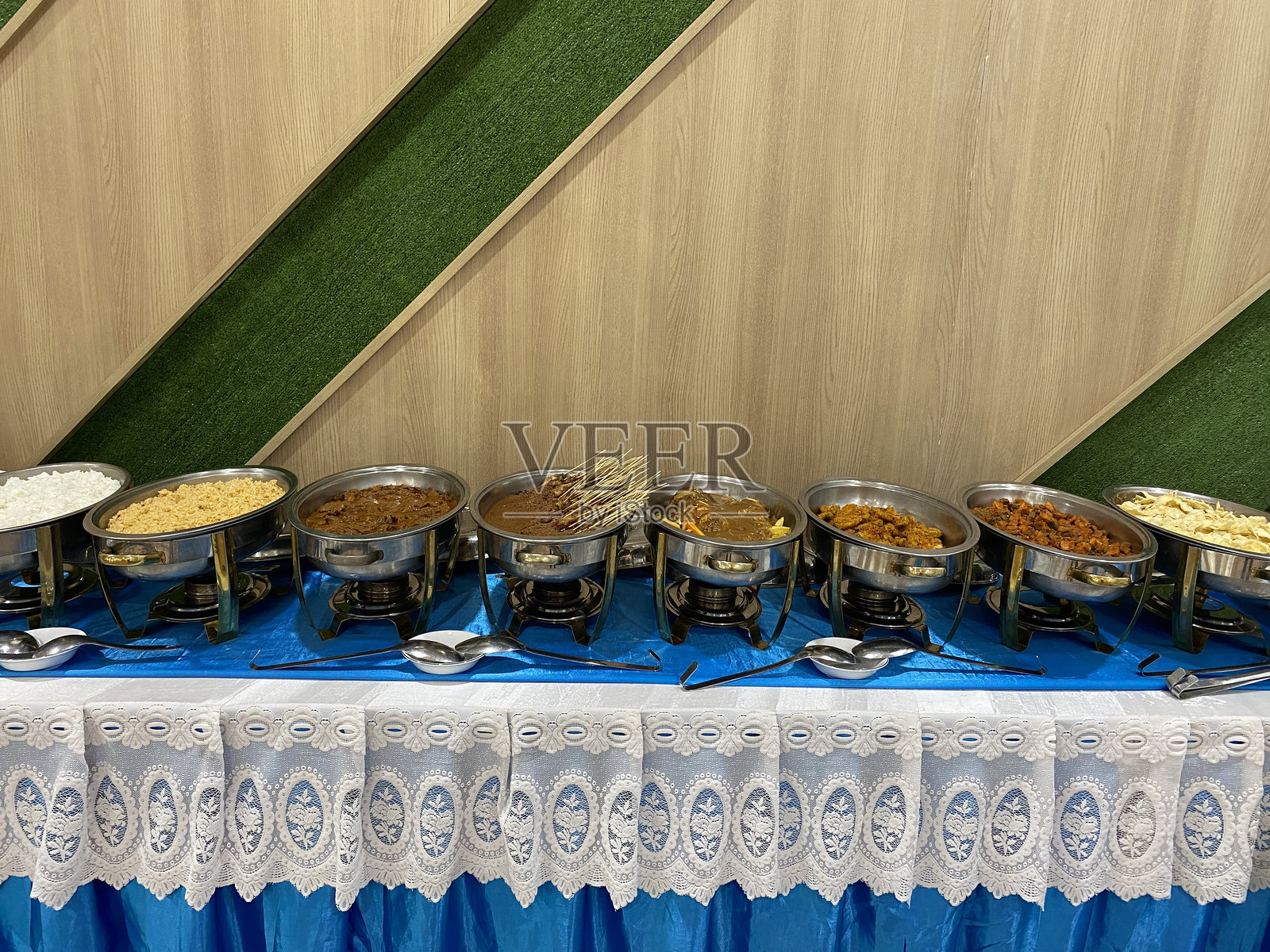 传统印尼自助餐，摆满各种菜肴和米饭，准备上桌。照片摄影图片