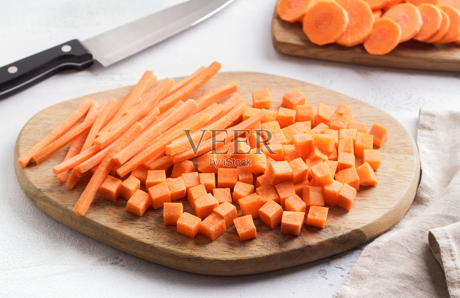 新鲜成熟的胡萝卜切成块和条放在木板上，两种切割蔬菜。健康饮食食品照片摄影图片