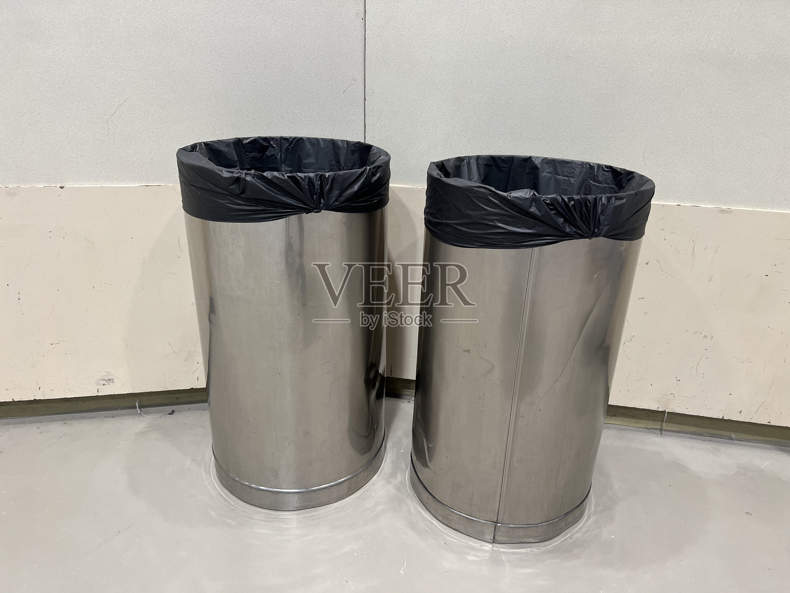 一对时尚现代的不锈钢垃圾桶或废物箱，适用于环保和可持续的废物处理，以及商业、办公室或家庭环境中的简约室内装饰。照片摄影图片